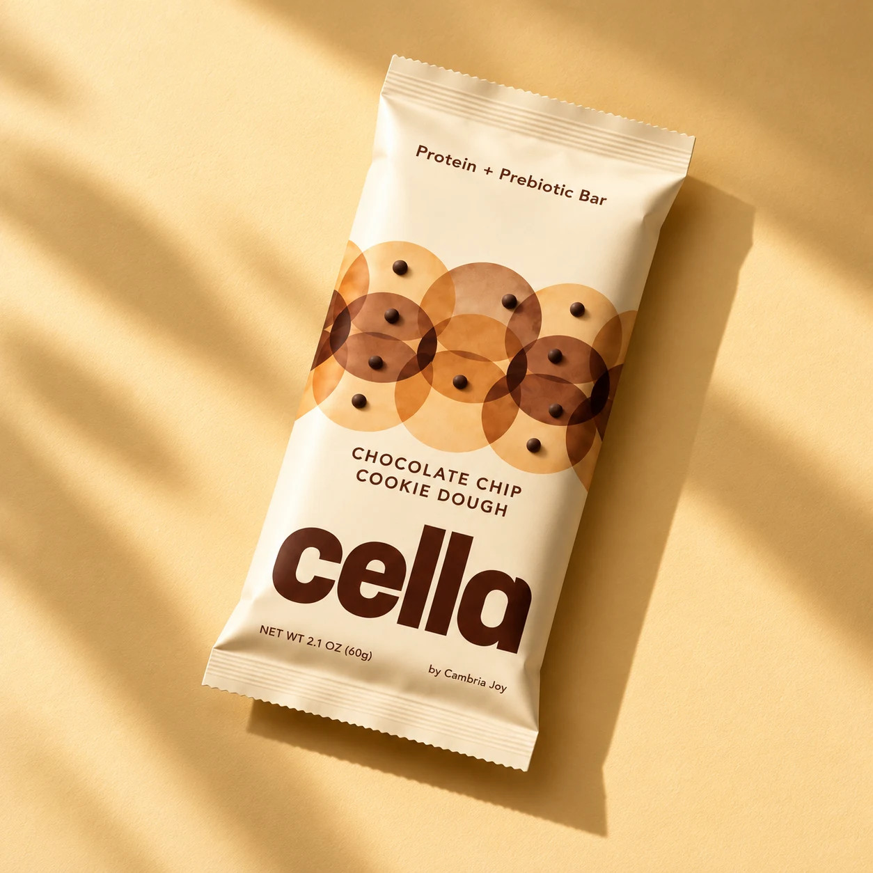 cella Chocolate Chip Cookie Dough bar with chocolate dots and amber circles on a cream wrapper.