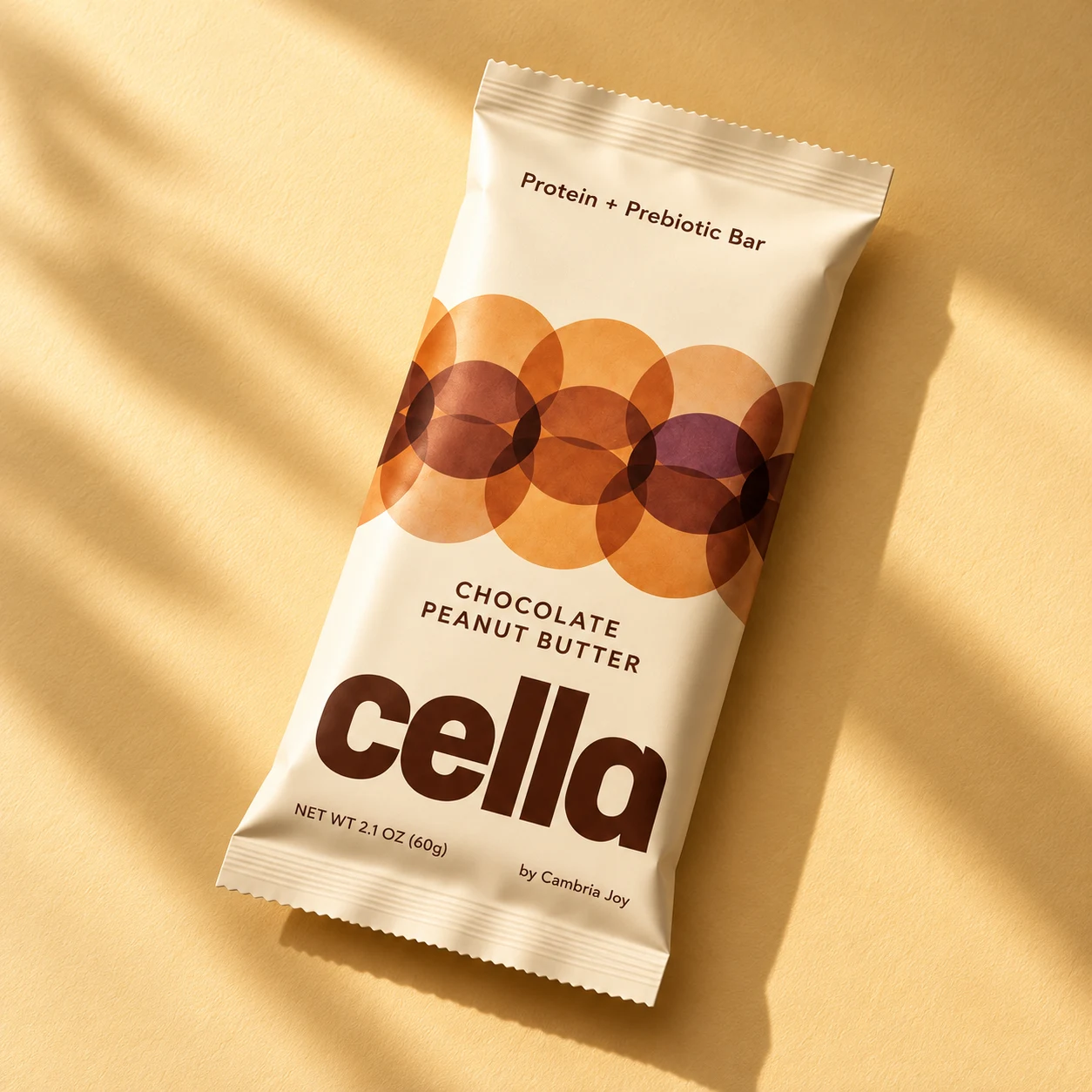 cella Chocolate Peanut Butter bar with warm overlapping circles on a buttery cream wrapper.